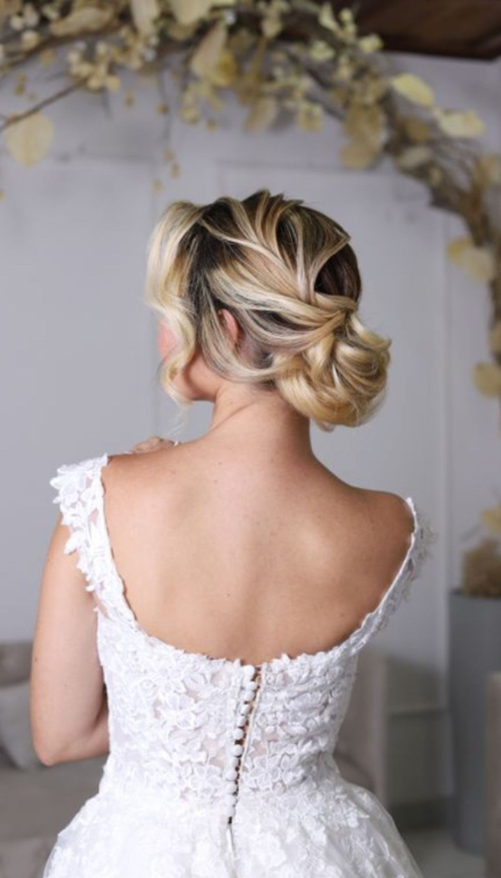Noiva com penteado elaborado e vestido branco — Studio Antonelli.