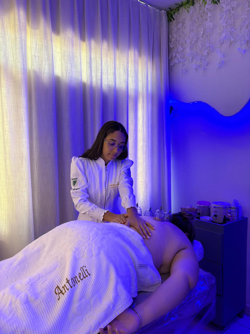 Profissional aplicando técnica de massagem em cliente, ambiente relaxante.